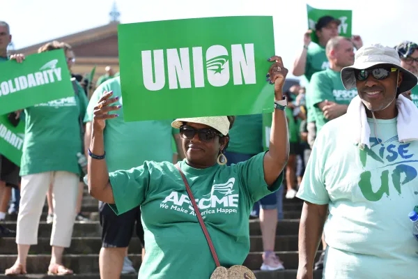AFSCME member holding "union" sign
